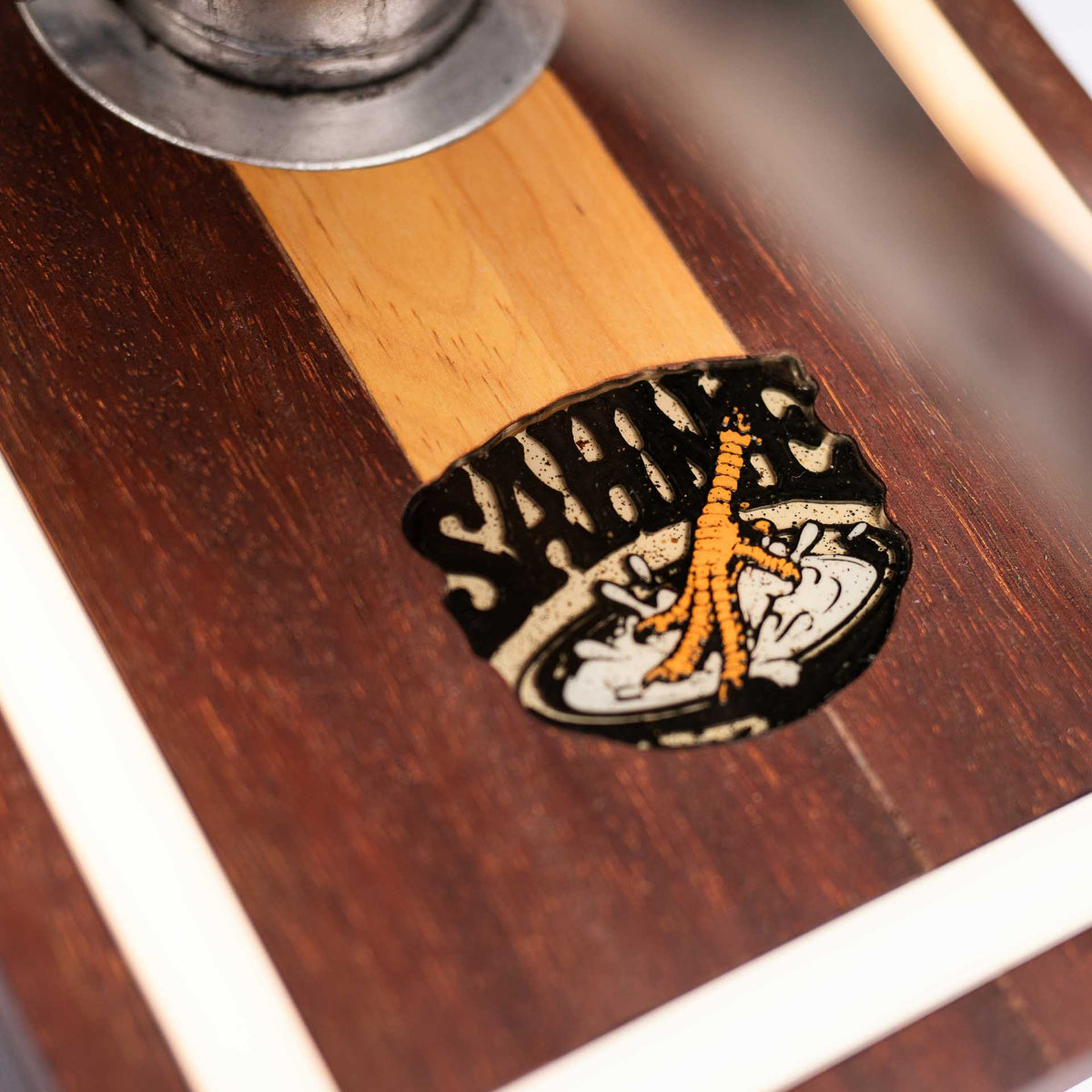 Close-up of the sahne.studio emblem inlaid in the wooden base