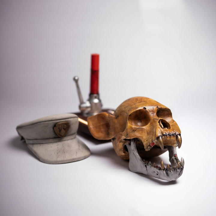 Dead Chase sculpture taken apart: skull, cap and base laid out on a light surface