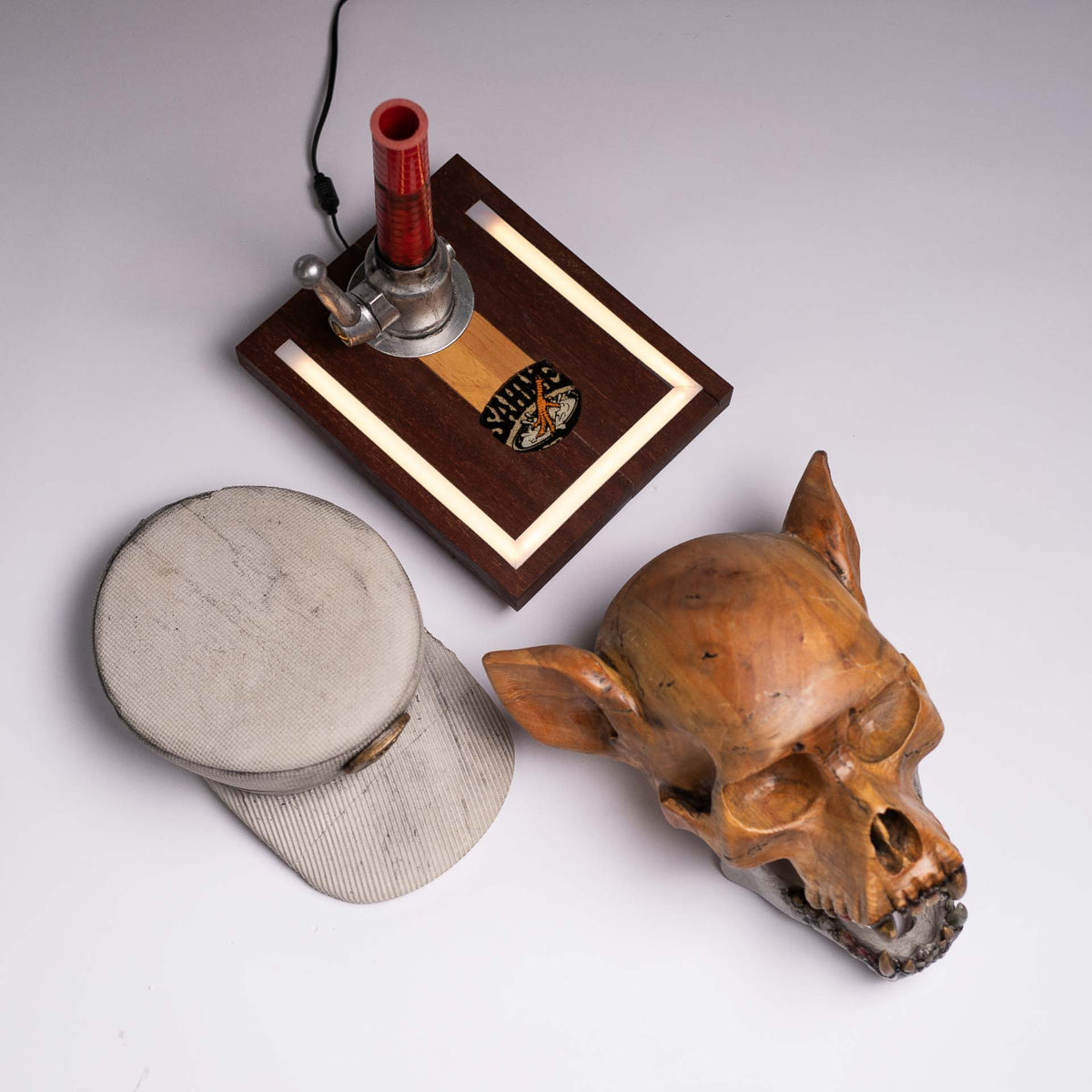 Top view of the four separate parts of the Dead Chase sculpture: skull, cap, jaw and illuminated base