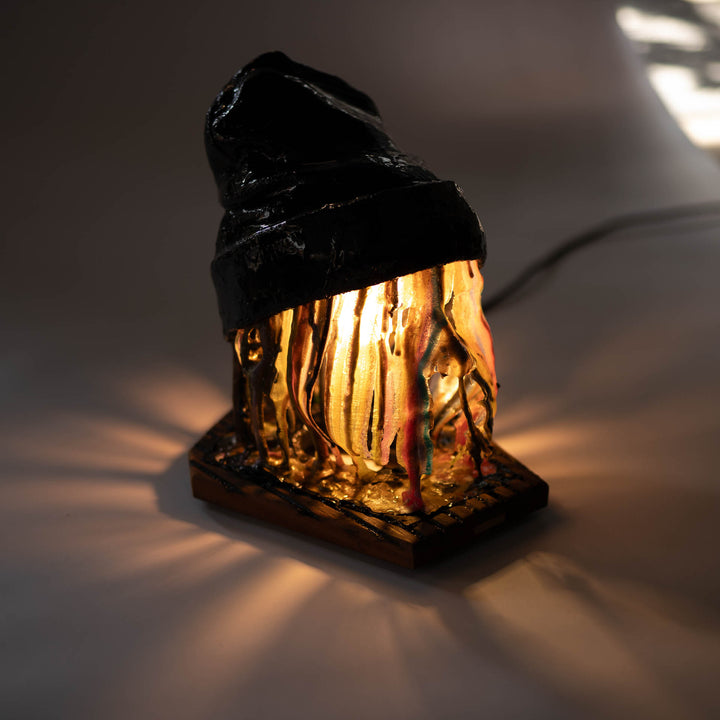 Melting Sahne sculpture lit from within, casting rays of warm light onto the surface